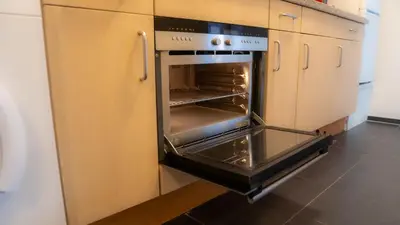an oven with its door open in a kitchen at Shoreline Apartment Katwijk in Katwijk aan Zee