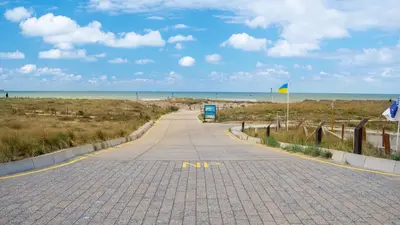 a road leading to a beach with the ocean at Shoreline Apartment Katwijk in Katwijk aan Zee