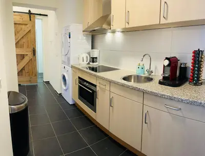 a kitchen with a sink and a counter top at Shoreline Apartment Katwijk in Katwijk aan Zee