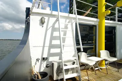 a white ladder on the side of a boat at Magnificent houseboat with a stunning view! in Amsterdam