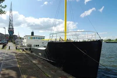 a boat docked at a dock in the water at Magnificent houseboat with a stunning view! in Amsterdam