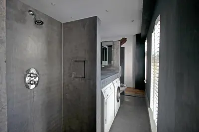 a bathroom with a shower with a mask on the wall at Elegant penthouse LOFT of 250 m2 in city centre with huge roofgarden 80 m2 in Amsterdam