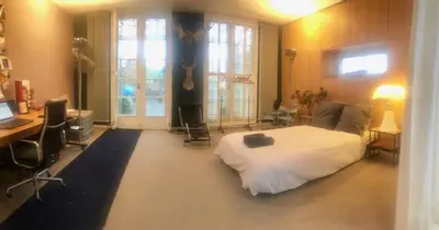 a bedroom with a bed and a desk and a computer at Elegant penthouse LOFT of 250 m2 in city centre with huge roofgarden 80 m2 in Amsterdam