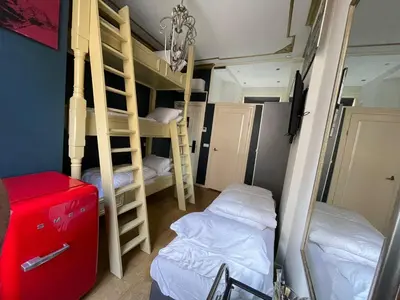 a room with bunk beds and a red suitcase at Amsterdam Rembrandt Square city center Hotel in Amsterdam