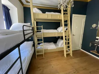a room with two bunk beds and a chandelier at Amsterdam Rembrandt Square city center Hotel in Amsterdam