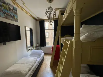 a room with two bunk beds and a chandelier at Amsterdam Rembrandt Square city center Hotel in Amsterdam