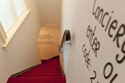 a stairwell with red stairs with writing on the wall at Amsterdam Rembrandt Square city center Hotel in Amsterdam