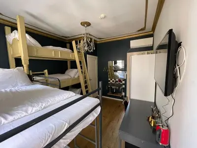 a bedroom with two bunk beds and a tv at Amsterdam Rembrandt Square city center Hotel in Amsterdam