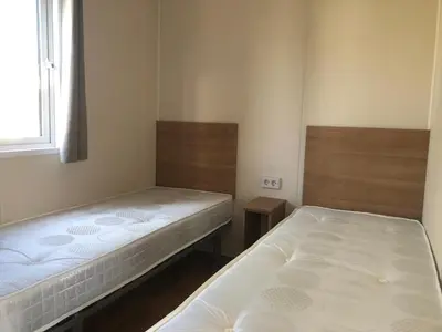 two beds in a small room with at Chalet 578 op Recreatiepark De Wielen in Sint Maarten