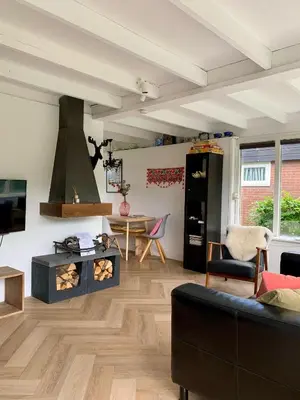 a living room with a fireplace and a table at Rekerlanden 79 in Warmenhuizen