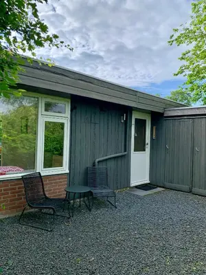 a house with two chairs and a table in front of it at Rekerlanden 79 in Warmenhuizen