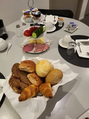 a table with a bunch of bread and pastries on it at B&B Adrina in Zeewolde