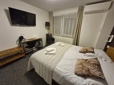 a hotel room with a bed with towels on it at B&B Adrina in Zeewolde