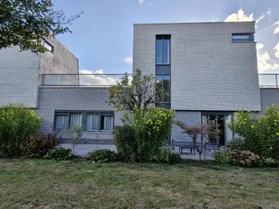 a brick house with a garden in front of it at B&B Adrina in Zeewolde