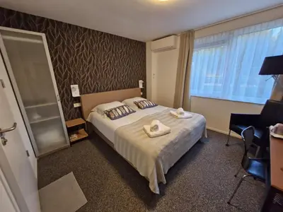a bedroom with a large bed with towels on it at B&B Adrina in Zeewolde