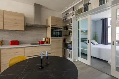 a kitchen with a table and a bed in a room at Nina's Beach House 2 