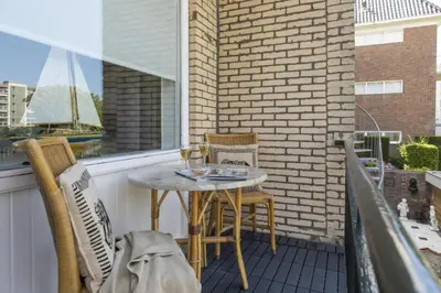 a patio with a table and chairs on a balcony at Nina's Beach House 2 