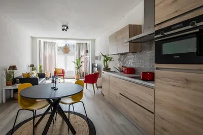 a kitchen and living room with a table and chairs at Nina's Beach House 2 