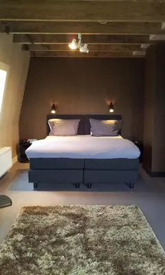 a bedroom with a large bed with a rug at V Lofts in Amsterdam