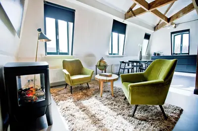 a living room with two chairs and a fireplace at V Lofts in Amsterdam