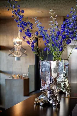a vase filled with purple flowers sitting on a table at V Lofts in Amsterdam