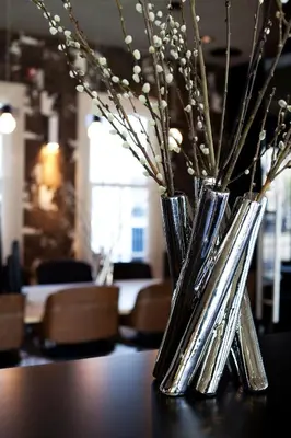 two vases sitting on a table with flowers in them at V Lofts in Amsterdam