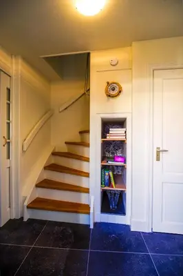 a staircase in a house with a book shelf at Unique Courtyard House with Sauna in Alkmaar city center in Alkmaar
