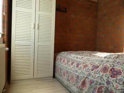 a bedroom with a bed and a brick wall at Ferienhaus-Naumann-Kreetz in Burgerbrug