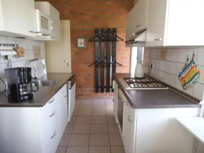 a kitchen with white appliances and a brick wall at Ferienhaus-Naumann-Kreetz in Burgerbrug