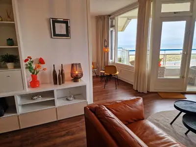 a living room with a couch and a view of the ocean at Studio Noordzee in Egmond aan Zee