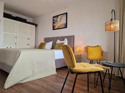 a bedroom with a bed and a table and chairs at Studio Noordzee in Egmond aan Zee