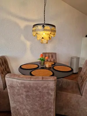 a dining room with a table and a chandelier at Studio Noordzee in Egmond aan Zee