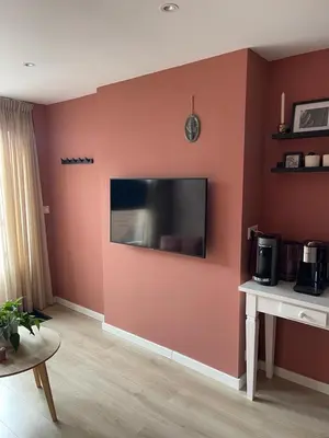 a living room with a television on a wall at Overnachten bij de Haven in Lelystad