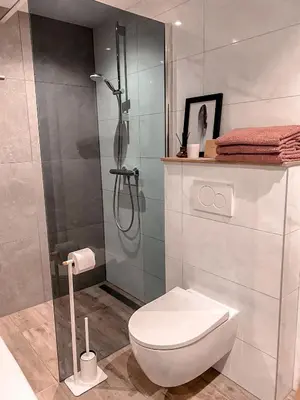 a bathroom with a toilet and a glass shower at Overnachten bij de Haven in Lelystad