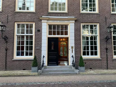 a brick building with a black door and stairs at Fortuna Spinoza in Monnickendam