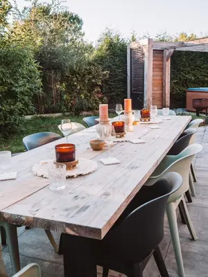 a long wooden table with chairs around it at Luxurious Family Villa with sauna big garden and jacuzzi in Zeewolde