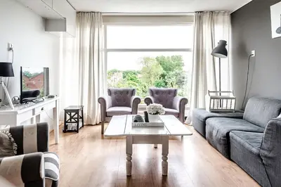 a living room with a couch and a table at Chapeau apartment in Zandvoort