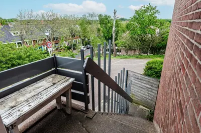 a wooden bench sitting on the side of a building at Chapeau apartment in Zandvoort