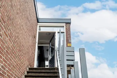 an open door of a brick building with stairs at Chapeau apartment in Zandvoort