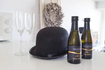 two bottles of wine and a hat on a counter with glasses at Chapeau apartment in Zandvoort