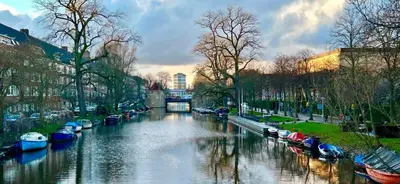 a river with boats parked on the sides of it at Authentic Amsterdam Bed and Breakfast Rai in Amsterdam