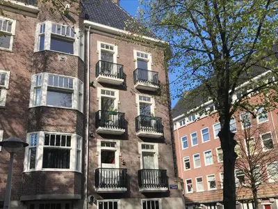 a brick building with balconies on the side of it at Authentic Amsterdam Bed and Breakfast Rai in Amsterdam