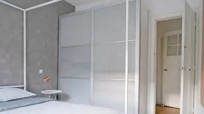 a bedroom with a large glass cabinet next to a bed at Authentic Amsterdam Bed and Breakfast Rai in Amsterdam