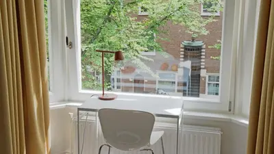 a window with a table and a lamp in front of it at Authentic Amsterdam Bed and Breakfast Rai in Amsterdam