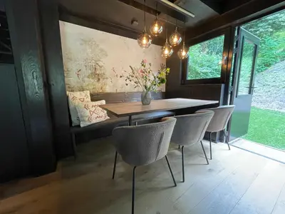 a dining room with a wooden table and chairs at Park Heerehof in Schoorl