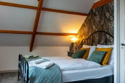 a bedroom with a bed with a black iron headboard at Munnik's Hof in Amsterdam
