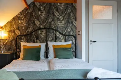 a bed with a headboard and pillows in a room at Munnik's Hof in Amsterdam