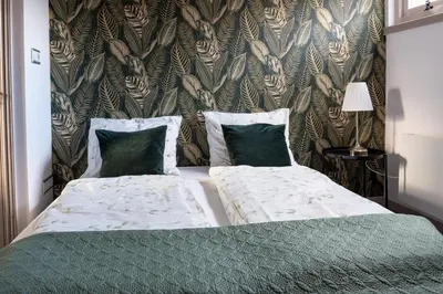 a bedroom with two beds with green sheets and a wallpaper at Munnik's Hof in Amsterdam