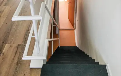 a staircase with white railings in a house at De Tuimelaar in Bergen aan Zee