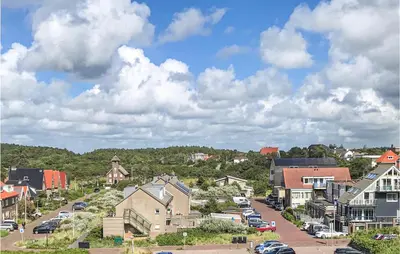 a small town with houses and cars on a street at De Tuimelaar in Bergen aan Zee
